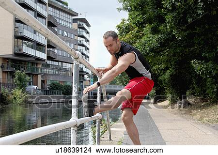 Runner stretching on city street View Large Photo Image Picture - Runner stretching on city street. Fotosearch