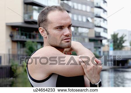 Stock Image - Runner stretching on city street. Fotosearch