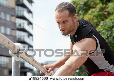 Runner stretching on city street View Large Photo Image Stock Photograph - Runner stretching on city street. Fotosearch