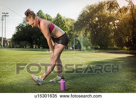 Runner stretching on grass in park View Large Photo Image Stock Photography - Runner stretching on grass in park. Fotosearch