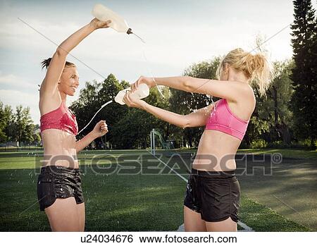 Stock Photograph - Runners splashing each other in park. Fotosearch