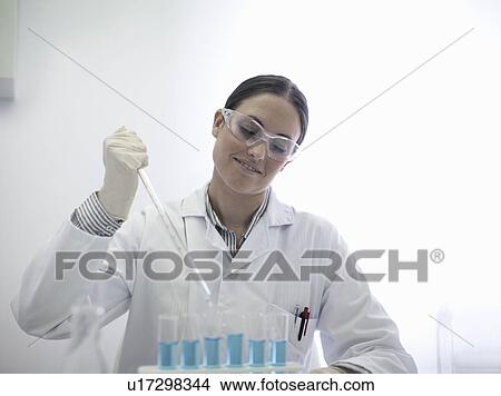 Scientist pipetting liquid in test tubes View Large Photo Image Picture - Scientist pipetting liquid in test tubes. Fotosearch