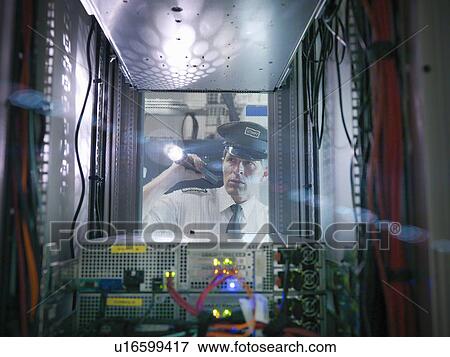 Stock Photo - Security guard inspecting server room. Fotosearch