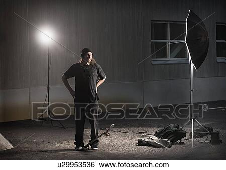 Stock Photograph - Skater standing under photo lights. Fotosearch