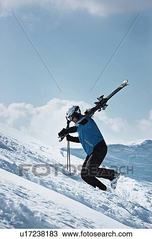 Skier climbing up snowy mountainside View Large Photo Image Stock Image - Skier climbing up snowy mountainside. Fotosearch