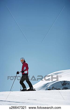 Stock Image - Skier coasting on snowy slope. Fotosearch