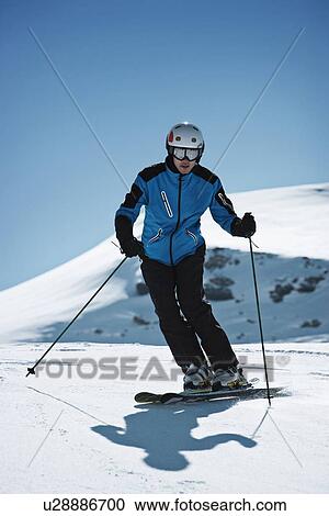 Stock Image - Skier coasting on snowy slope. Fotosearch