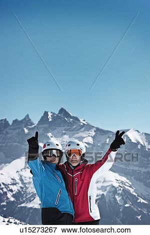Stock Photo - Skiers cheering on snowy mountain. Fotosearch