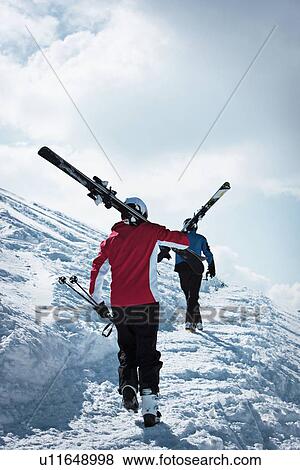 Skiers climbing up snowy mountainside View Large Photo Image Stock Photo - Skiers climbing up snowy mountainside. Fotosearch