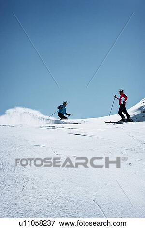 Stock Photo - Skiers coasting on snowy slope. Fotosearch