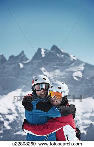 Skiers hugging on snowy mountain View Large Photo Image Stock Image - Skiers hugging on snowy mountain. Fotosearch