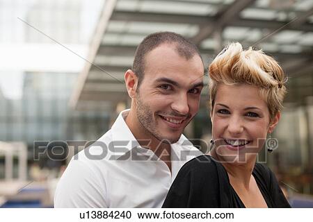 Stock Image - Smiling couple hugging outdoors. Fotosearch