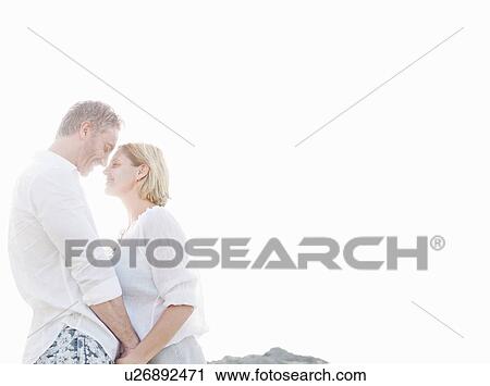 Stock Image - Smiling couple hugging outdoors. Fotosearch