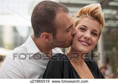 Smiling couple kissing outdoors View Large Photo Image Stock Photo - Smiling couple kissing outdoors. Fotosearch
