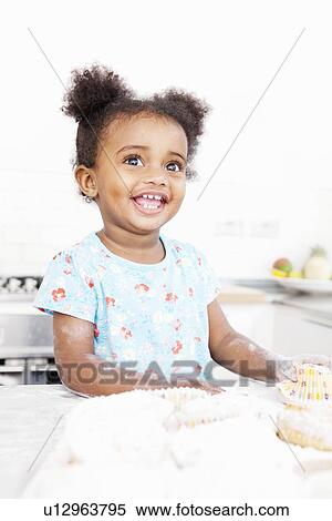 Smiling girl baking in kitchen View Large Photo Image Stock Photography - Smiling girl baking in kitchen. Fotosearch