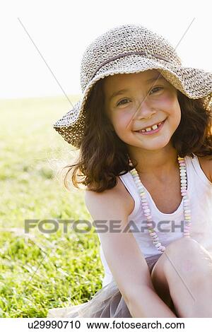 Smiling girl wearing sunhat outdoors View Large Photo Image Stock Image - Smiling girl wearing sunhat outdoors. Fotosearch