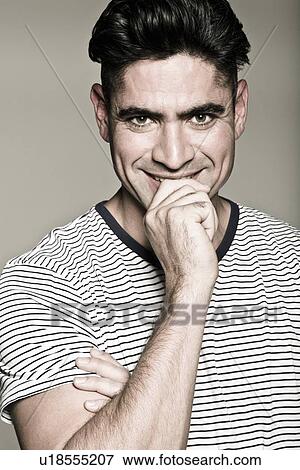 Stock Photo - Smiling man biting his finger. Fotosearch