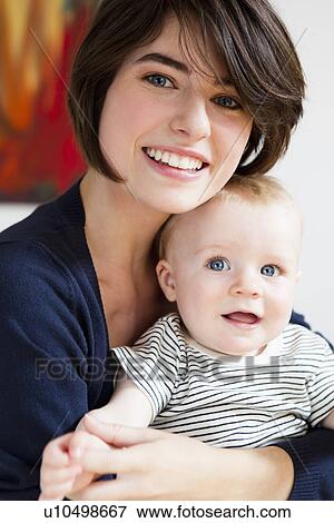 Stock Photo - Smiling mother holding baby. Fotosearch
