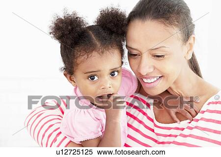 Stock Photography - Smiling mother holding daughter. Fotosearch