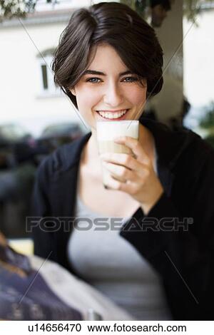 Smiling woman drinking coffee in cafe View Large Photo Image Stock Image - Smiling woman drinking coffee in cafe. Fotosearch