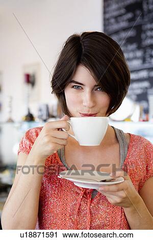 Smiling woman drinking coffee in cafe View Large Photo Image Stock Image - Smiling woman drinking coffee in cafe. Fotosearch
