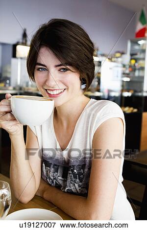 Smiling woman drinking coffee in cafe View Large Photo Image Stock Photo - Smiling woman drinking coffee in cafe. Fotosearch