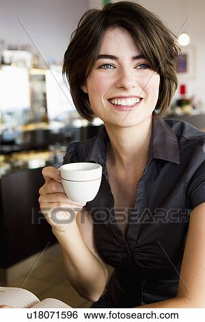Smiling woman having coffee in cafe View Large Photo Image Stock Photograph - Smiling woman having coffee in cafe. Fotosearch