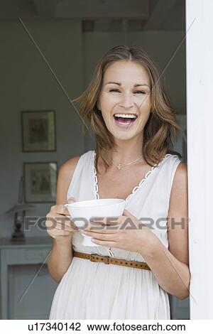 Stock Image - Smiling woman having cup of coffee. Fotosearch