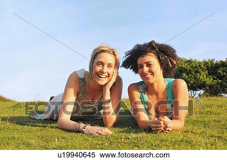 Stock Photography - Smiling woman laying in grass. Fotosearch