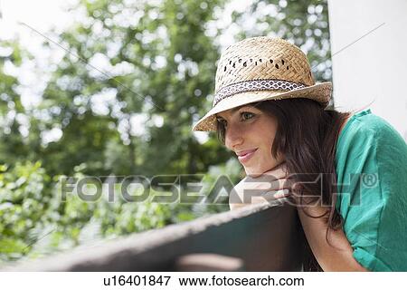 Smiling woman leaning on banister View Large Photo Image Stock Photo - Smiling woman leaning on banister. Fotosearch