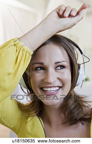 Smiling woman listening to headphones View Large Photo Image Stock Photography - Smiling woman listening to headphones. Fotosearch