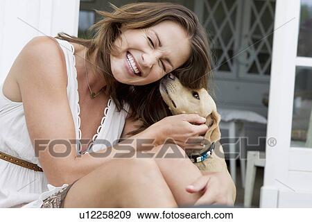 Smiling woman playing with dog View Large Photo Image Stock Photo - Smiling woman playing with dog. Fotosearch
