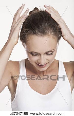 Smiling woman pulling back her hair View Large Photo Image Stock Photo - Smiling woman pulling back her hair. Fotosearch