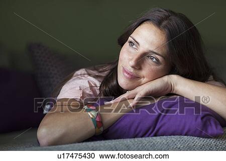 Smiling woman relaxing on sofa View Large Photo Image Stock Image - Smiling woman relaxing on sofa. Fotosearch