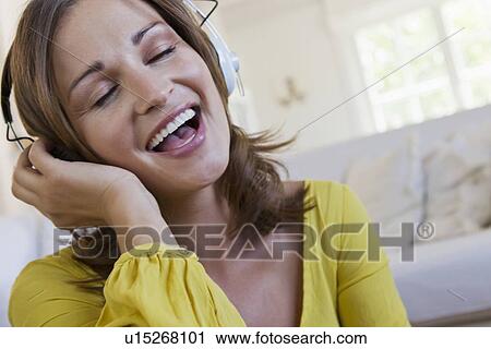 Smiling woman singing to headphones View Large Photo Image Stock Image - Smiling woman singing to headphones. Fotosearch