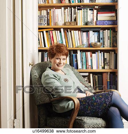 Stock Photo - Smiling woman sitting in armchair. Fotosearch