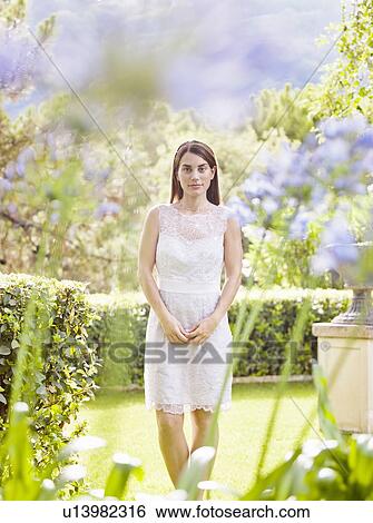 Smiling woman standing in garden View Large Photo Image Stock Photograph - Smiling woman standing in garden. Fotosearch