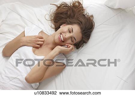 Stock Image - Smiling woman talking on cell phone. Fotosearch