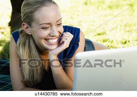 Smiling woman using laptop outdoors View Large Photo Image Stock Photography - Smiling woman using laptop outdoors. Fotosearch