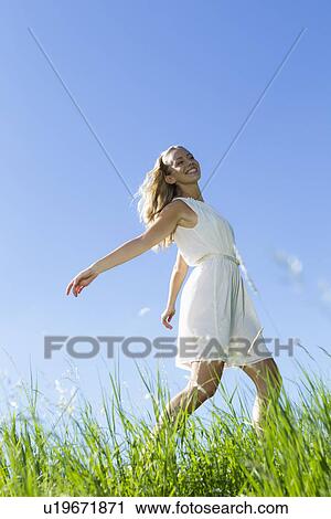 Smiling woman walking in tall grass View Large Photo Image Stock Image - Smiling woman walking in tall grass. Fotosearch