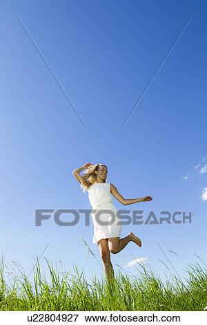 Smiling woman walking in tall grass View Large Photo Image Stock Photo - Smiling woman walking in tall grass. Fotosearch