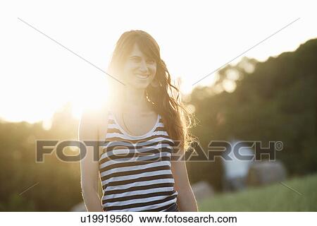 Stock Image - Smiling woman walking outdoors. Fotosearch