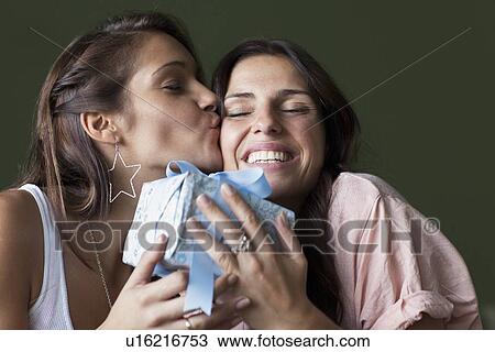 Stock Image - Smiling women exchanging gifts. Fotosearch
