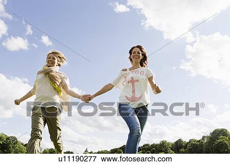 Smiling women running outdoors View Large Photo Image Stock Photo - Smiling women running outdoors. Fotosearch
