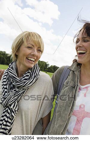 Picture - Smiling women walking together outdoors. Fotosearch