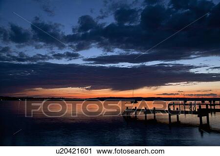 Sun setting over still rural lake View Large Photo Image Stock Image - Sun setting over still rural lake. Fotosearch