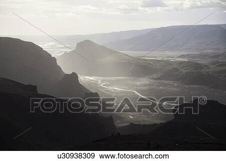 Stock Photo - Sun shining on rocky valley river. Fotosearch
