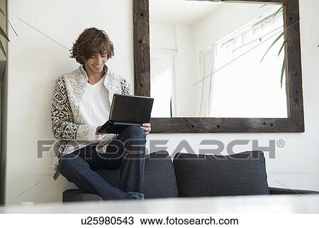 Teenage boy using laptop on sofa View Large Photo Image Stock Image - Teenage boy using laptop on sofa. Fotosearch
