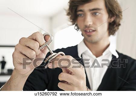 Teenage boy working on metal puzzle View Large Photo Image Stock Image - Teenage boy working on metal puzzle. Fotosearch