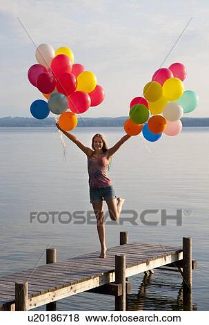 Teenage girl holding balloons on pier View Large Photo Image Stock Photo - Teenage girl holding balloons on pier. Fotosearch